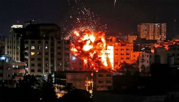 An explosion is pictured among buildings during an Israeli airstike on Gaza City