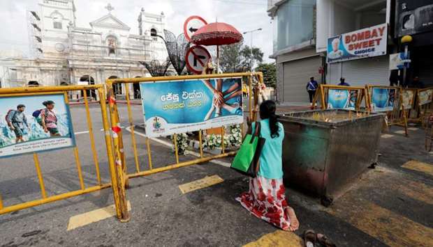 A Sri Lankan Catholic prays on the road in front of St. Anthony's Shrine, where an explosion took place during mass on Easter Sunday, in Colombo, Sri Lanka