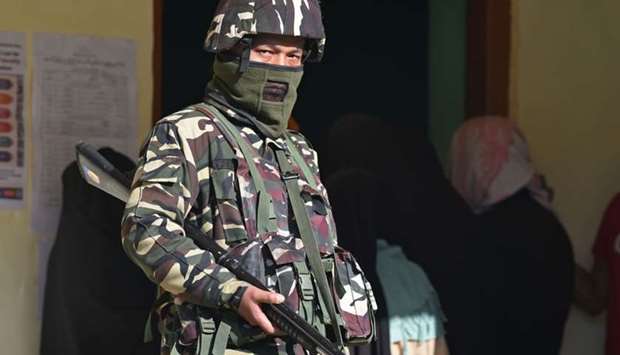 An Indian paramilitary trooper stands guard at a polling station during the third phase of India's general election, at Khanabal area of Anantnag district, south of Srinagar on April 23, 2019.