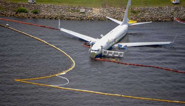 This image released by the US Navy shows containment and absorbent booms surroundng a Boeing 737 aircraft in the St. Johns River after the aircraft slid off the runway at Naval Air Station Jacksonville.  AFP/Navy Office of Information /Thomas A. Higgins