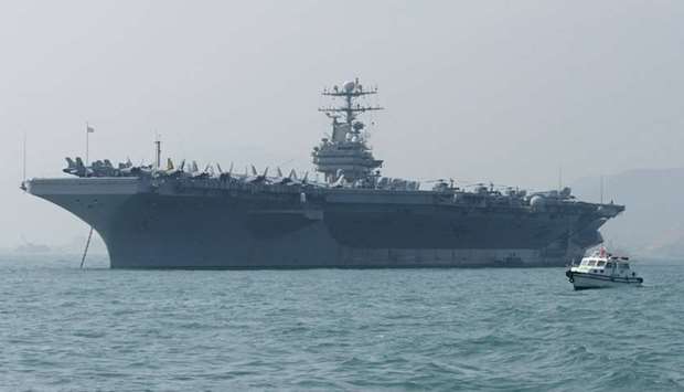 In this file photo taken on December 23, 2004 A small boat sails by the USS Abraham Lincoln moored in Hong Kong.