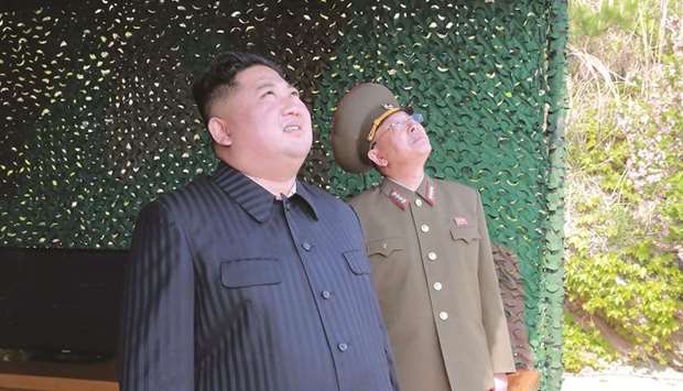 North Korean leader Kim Jong-un (left) supervising a u201cstrike drillu201d, a test of long-range multiple rocket launchers and tactical guided weapons, into the East Sea in an undisclosed location in North Korea.