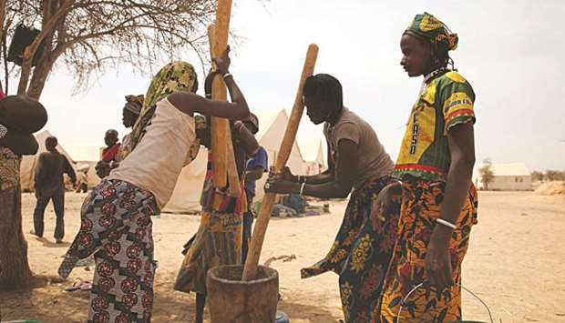 Women pound millet at a camp for internally displaced persons in Barsalogho in Burkina Faso on March 3, 2019.