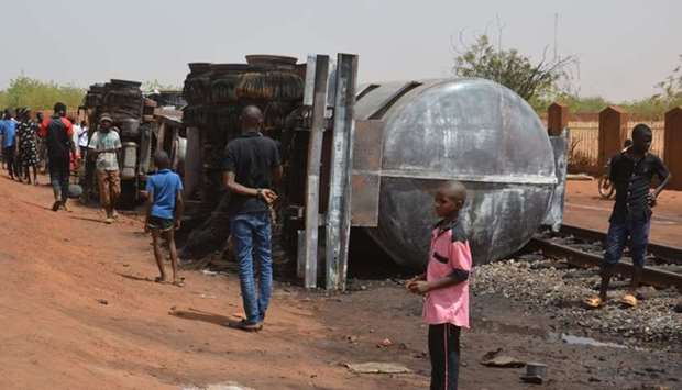 Residents look at a calcined tanker truck after an explosion which killed more than 55 people near the airport of Niamey yesterday.