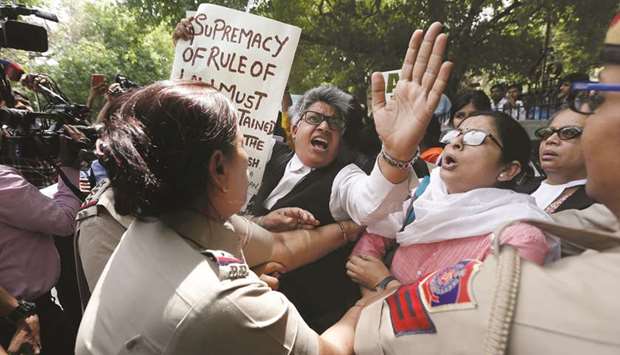 A policewoman detains a demonstrator during a protest after a panel of judges dismissed a sexual harassment complaint against chief justice of India Ranjan Gogoi, outside Supreme Court in New Delhi yesterday.