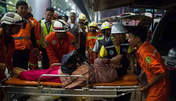 Rescue workers transport an injury passenger on a stretcher after a passenger aircraft of Biman Bang