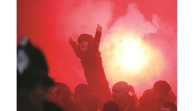 Liverpool fans celebrate  alongside a flare outside the stadium on Tuesday.