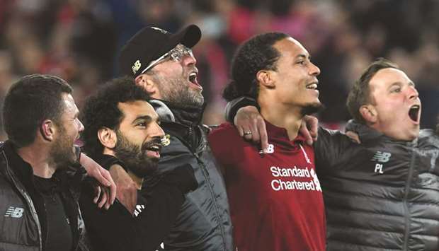 Liverpoolu2019s Egyptian midfielder Mohamed Salah (2L), German manager Jurgen Klopp (C) and Dutch defender Virgil van Dijk celebrate after winning the UEFA Champions league semi-final second leg football match against Barcelona at Anfield in Liverpool on Tuesday.