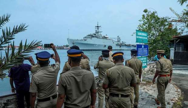 Indian Navy personnel watch and take photos as the INS Jalashwa ship enters the Cochin port carrying Indian citizens who were stranded in Maldives due to the coronavirus disease, in Kochi in the south Indian state of Kerala