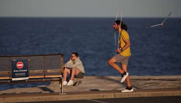 A man exercises during a clear evening on the coast amidst the easing of restrictions implemented to curb the spread of the coronavirus disease in Sydney, Australia,