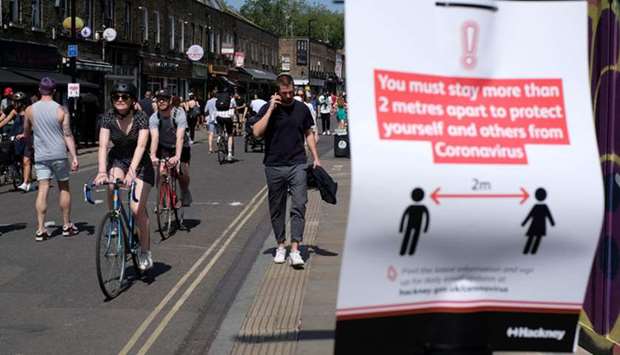 People walk and cycle along Londonu2019s Broadway Market, following the outbreak of the coronavirus disease.