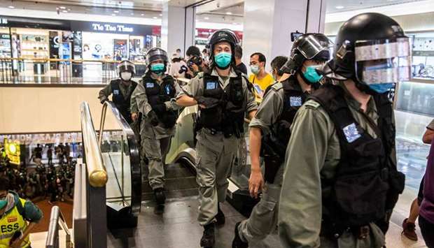 Riot police wear face masks, as a precautionary measure against the coronavirus, enter a shopping mall where protests by pro-democracy demonstrators call for the cityu2019s independence in Hong Kong yesterday.