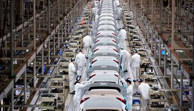 Employees work on a production line inside a Dongfeng Honda factory after lockdown measures in Wuhan on April 8