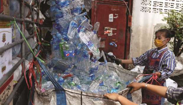 Women collect plastic bottles brought by a truck at a recycling plant during the coronavirus disease (Covid-19) outbreak in Bangkok yesterday.