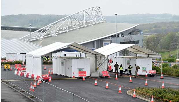 In this April 18, 2020, picture, staff and members of the armed forces prepare for the opening of a new testing facility for Covid-19 for NHS workers at the AMEX Stadium in Brighton. (AFP)