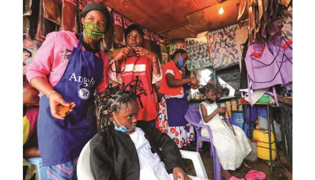 Martha Apisa, 12, and Stacy Ayuma, 8, get plaited with the u2018coronavirusu2019 hairstyle at the Mama Brayo Beauty Salon within Kambi-Muru village of Kibera slums in Nairobi.