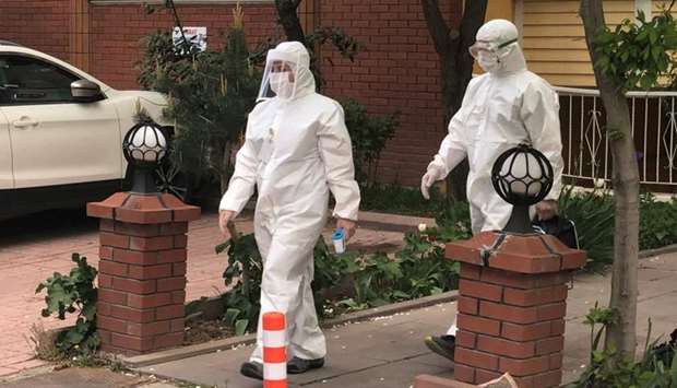 Medics wearing protective suits, members of Turkish Health Ministry's coronavirus contact tracing team, leave after visiting a home to check a suspected coronavirus disease case in Ankara