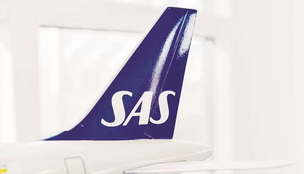 The SAS logo sits on the tail fin of a model aircraft at the companyu2019s headquarters in Stockholm. SAS said that the latest dismissals, amounting to 40% of the workforce, are necessary because employees have an average notice period of six months and it needs to prepare for what may be years of sluggish demand.