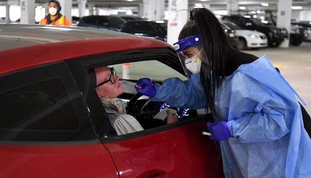 (File photo) Medical staff perform a test for the coronavirus at a drive-through testing site in Melbourne.
