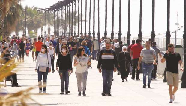 People walk along Beirutu2019s seaside Corniche, as Lebanese authorities warned of a new wave of the coronavirus disease in Beirut, on May 10. Lebanon defaulted on its foreign currency debt in March, while its currency has lost more than half its value since October. Savers have largely been shut out of foreign exchange deposits as the supply of dollars has grown scarce.