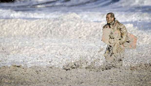 A rescue worker stands in rough waters, searching for missing surfers in the North Sea at Scheveningen, The Netherlands.