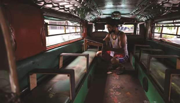 A driver installs seat dividers in his passenger jeepney to comply with government-imposed social distancing rules against the Covid-19 coronavirus in Manila.