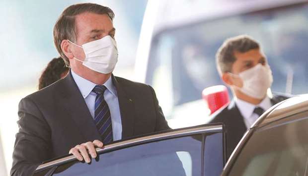 Brazilu2019s President Jair Bolsonaro wearing a protective face mask leaves Alvorada Palace in Brasilia.