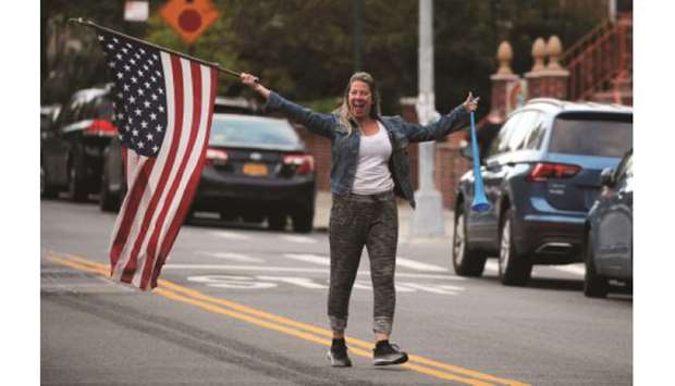 A woman waves a flag during the evening u2018clap and cheer for healthcare workersu2019 in the Brooklyn borough of New York City.