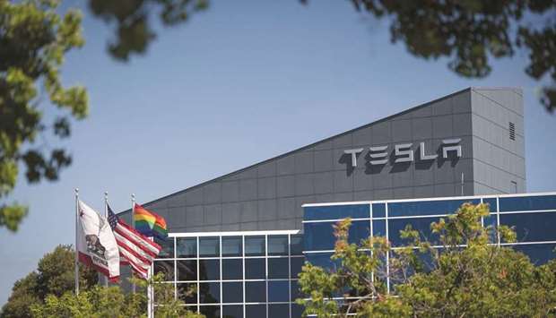 Flags fly outside of a Tesla building in Fremont, California. Health officers for Alameda County said late on Tuesday that the factory can reopen if Tesla adopts safety recommendations in addition to a new plan the company submitted on Monday.