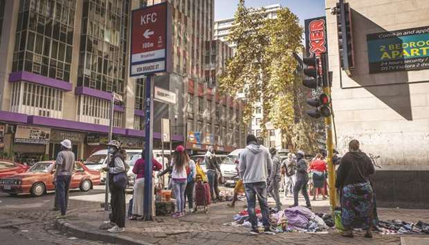 People gather on a street corner in the Central Business District of Johannesburg. Almost 1bn people in Johannesburg, South Africau2019s commercial hub, are in need of food aid due to movement restrictions imposed to curb the coronavirus pandemic, according to its mayor. Africa owes almost $150bn, or about 20% of all government external debt to China, according to the relief group Jubilee Debt Campaign.
