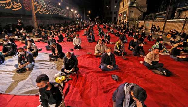 Iranians, some wearing face masks against the Covid-19 coronavirus, attend Laylat al-Qadr prayers, one of the holiest nights during the fasting month of Ramadan, outside a mosque in Tehran, yesterday.