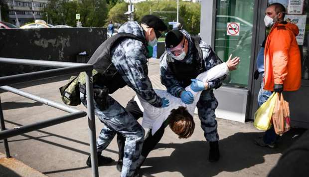 Members of the Russian National Guard (Rosgvardia) detain a man in front of a supermarket in  Moscow. To avoid an escalation in the number of infections, the city authorities have made it mandatory to wear gloves and a mask on public transport, shops and other pubic places, on pain of a fine of 5,000 roubles (about u20ac63).