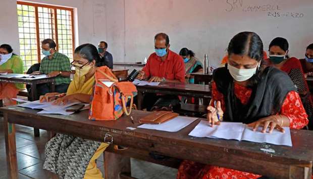 Teachers wearing facemasks evaluate the Higher Secondary examination papers at SRV School in Kochi yesterday.