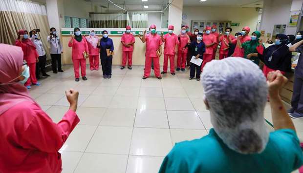 Healthcare workers wearing protective face masks gesture for the coronavirus disease patients during a briefing in the emergency room at Persahabatan Hospital in Jakarta yesterday.