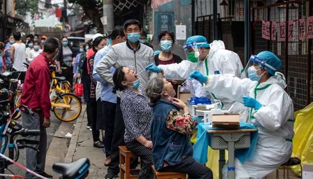 Medical workers take swab samples from residents to be tested for the COVID-19 coronavirus in a street in Wuhan in China\'s central Hubei province