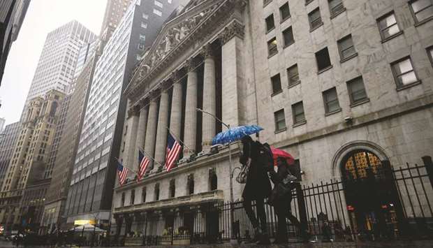 People pass the New York Stock Exchange building. Investors are bracing for more turbulence in US stocks, as some states prepare to reopen their economies and global trade tensions rise.