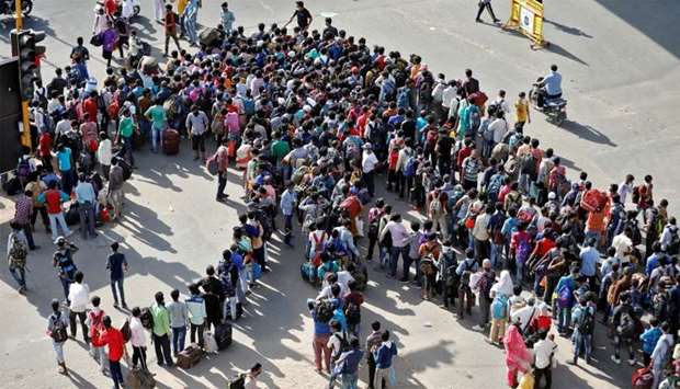 Migrant workers and their families gather to get on buses to reach to a railway station to board trains to their home states, after a limited reopening of India's giant rail network following a nearly seven-week lockdown to slow the spreading of the coronavirus disease (COVID-19), in Ahmedabad