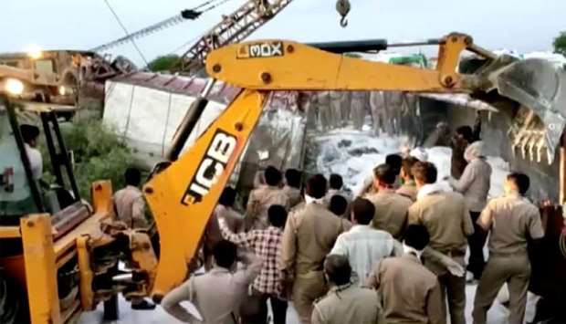 A police rescue team work to lift a truck afterat the site of an accident where a truck carrying migrant labourers collided with another, killing and injuring several people in Auraiya, Uttar Pradesh, India