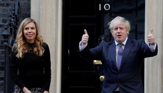 Britain's Prime Minister Boris Johnson and his partner Carrie Symonds applaud outside 10 Downing Street during the Clap for our Carers campaign in support of the NHS, following the outbreak of the coronavirus disease in London