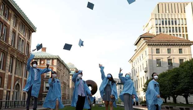 Masters students from the Columbia University Graduate School of Architecture, Planning and Preservation throw their graduation caps in the air for a photo the day before their graduation ceremony, which is to be held online due to the outbreak of the coronavirus disease in Manhattan, New York City.