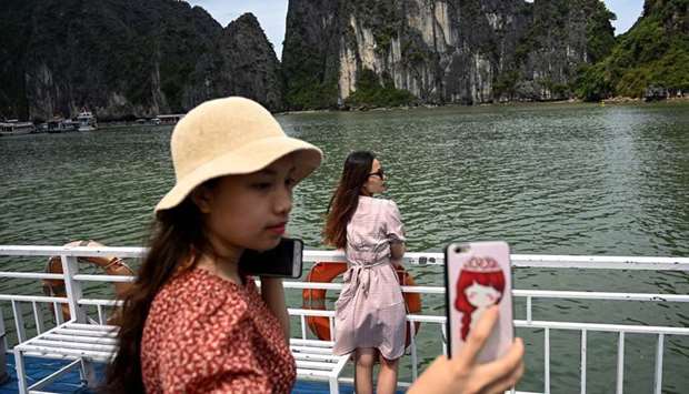 Local tourists pose for photographs on a boat in the midst of Ha Long Bay in northeastern province of Quang Ninh yesterday.