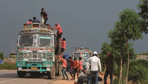 Migrant workers climb onto a truck to return to their hometowns on the outskirts of Hyderabad yesterday.