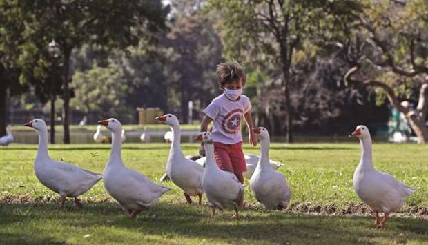A boy runs after geese at a park after authorities allowed children to go out for an hour for recreational purposes according to the ID number of their parents u2013 some on Saturdays and others on Sundays u2013 amid the lockdown imposed against the spread of the new coronavirus in Buenos Aires.