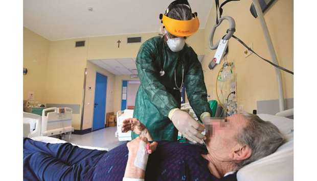 Doctor Roberto Arias Hernandez examines an elderly patient in a non-Covid medicine ward at the Maggiore Hospital of Crema, southeast of Milan.