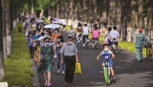 People walk in Moshan Scenic Area Qinshui Platform in the East Lake in Wuhan, in Chinau2019s central Hubei province. Authorities in the pandemic ground zero of Wuhan have ordered mass Covid-19 testing for all 11mn residents after a new cluster of cases emerged over the weekend.