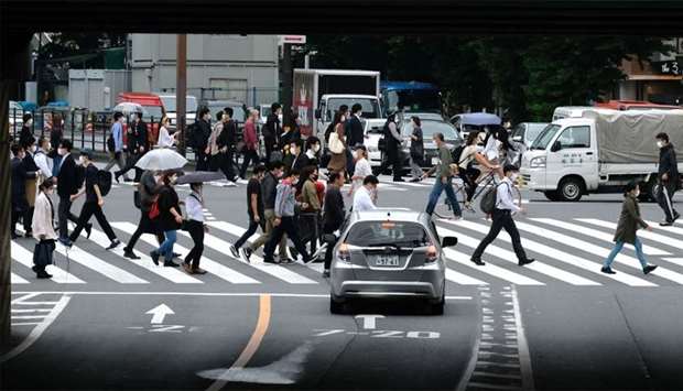 Pedestrians walk on a crossing in Tokyo, Japan