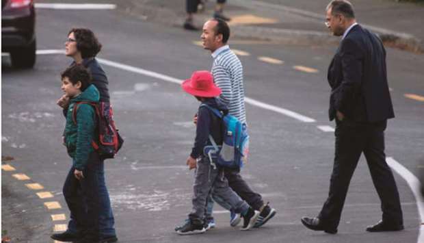 Schoolchildren and their parents make their way to school after the government allowed schools to reopen under Level 2 guidelines in Wellington yesterday.
