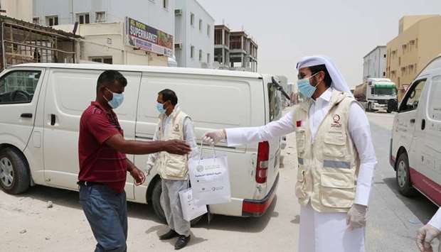QFC, Qatar Charity volunteers distribute protective kits to Industrial Area workers.