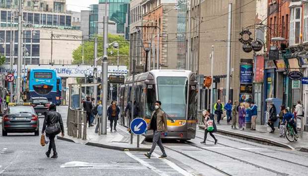 People cross the tram tracks in Dublin City centre in Ireland yesterday as Ireland cautiously begins to lift its coronavirus lockdown.