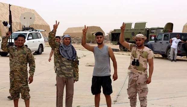 Members of Libyau2019s internationally recognised government flash victory signs after taking control of Watiya air base, southwest of Tripoli, yesterday.